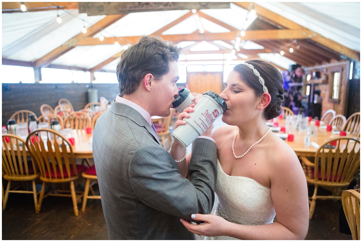 The wedding couple share hot drinks with intertwined arms at their Colorado mountain elopement.