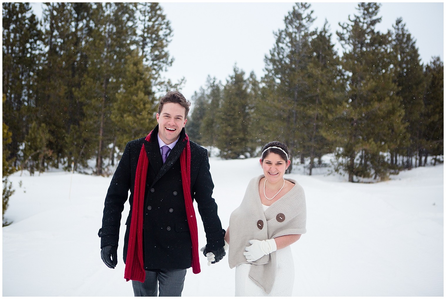 The wedding couple walk together through the snow at their Breckenridge Colorado mountain elopement.