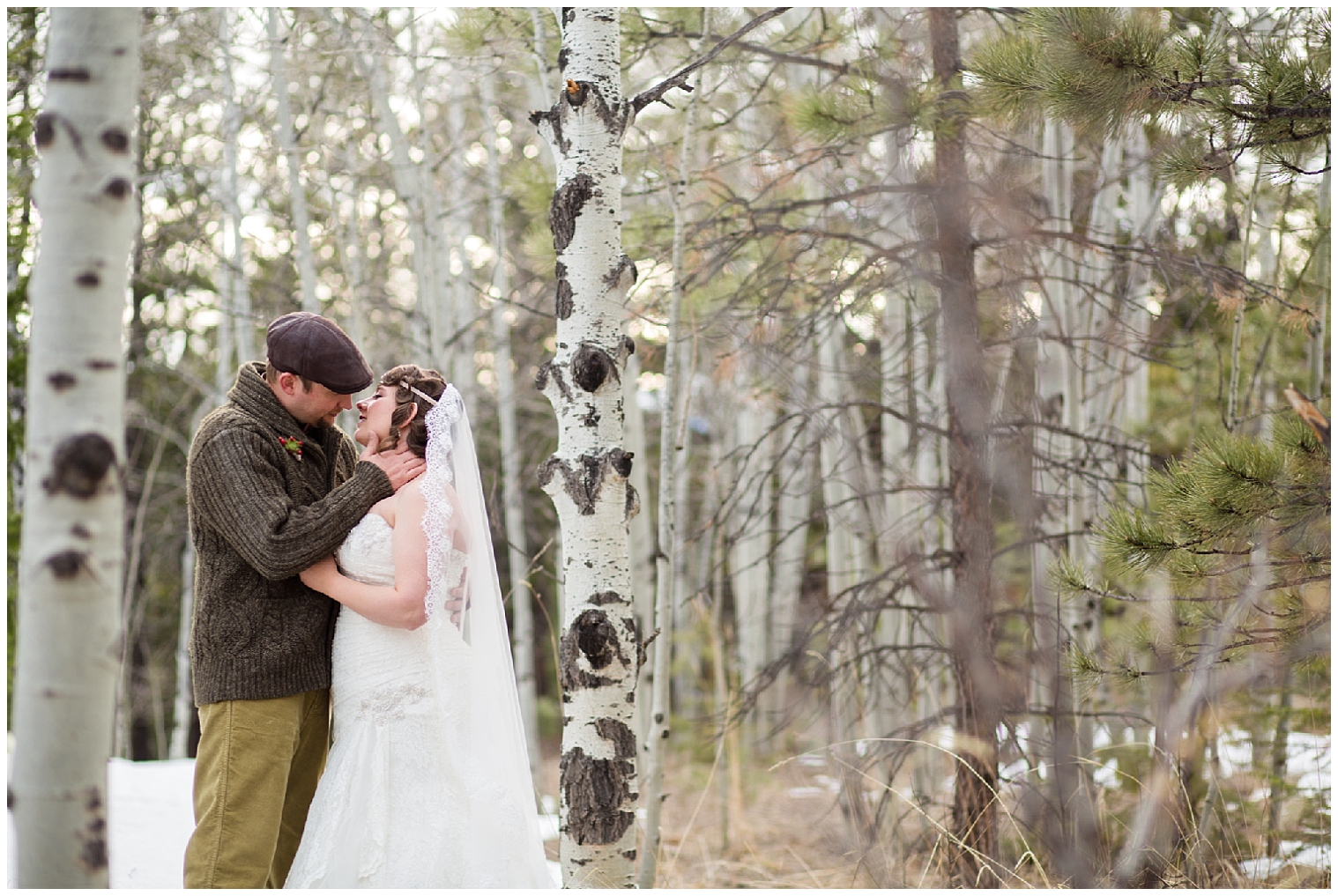 The wedding couple lean in for a kiss amount the trees at their Boulder elopement.