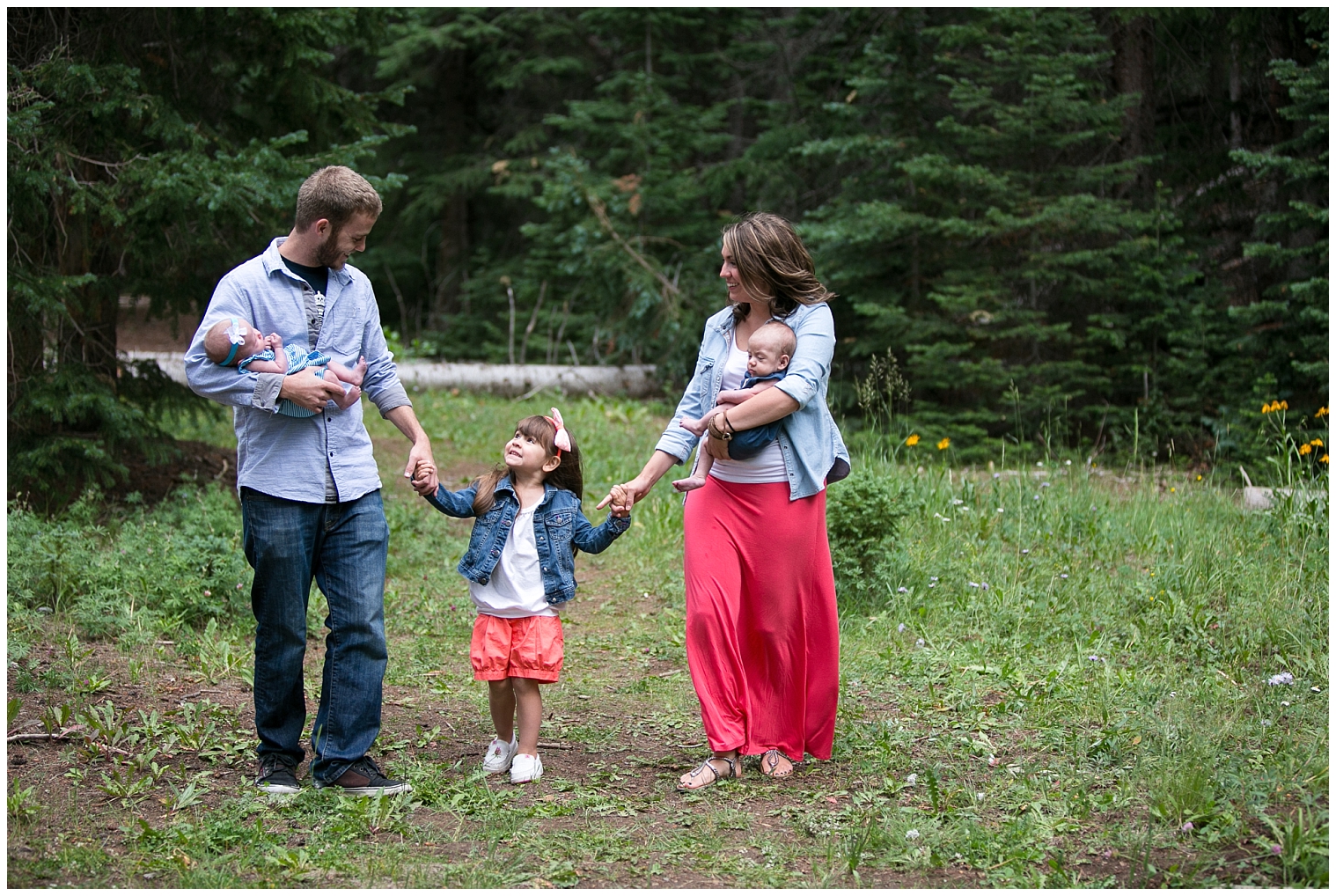 At a Colorado extended family session, parents hold their babies and their little girl's hands.