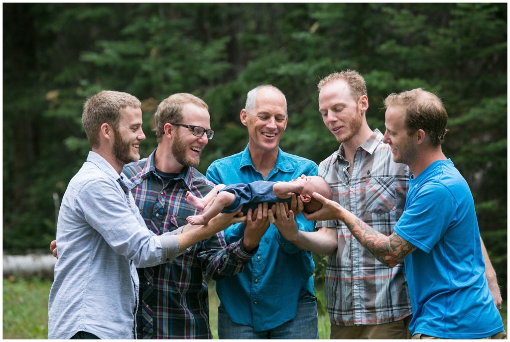 At a Colorado family photo session, the men of the family pose with a newborn baby boy.