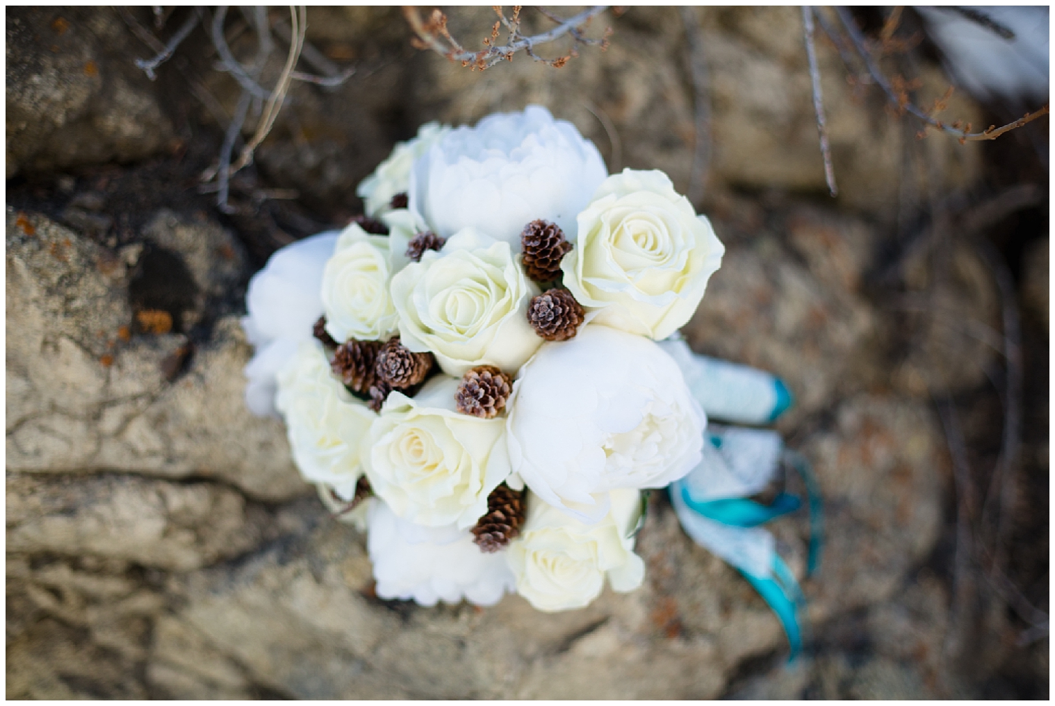 Bridal bouquet of white roses and pine cones at a Boreas Pass Breckenridge elopement.