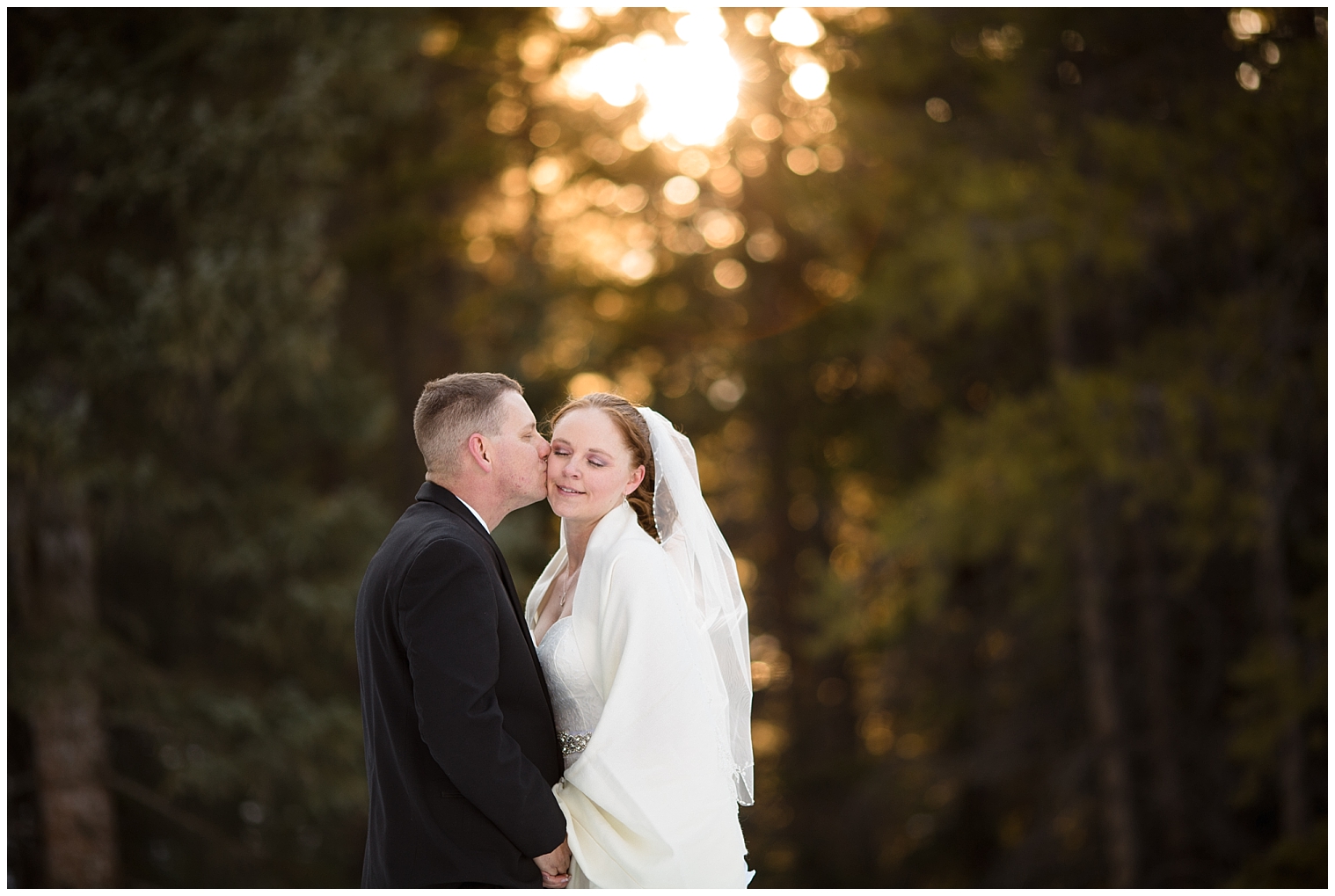 Groom kiss his bride on the cheek during portraits at their Colorado mountain elopement.