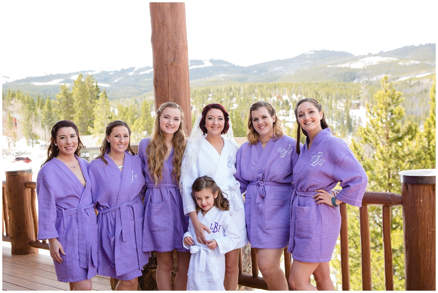 Bride and bridesmaids wearing matching robes before a Seven wedding.
