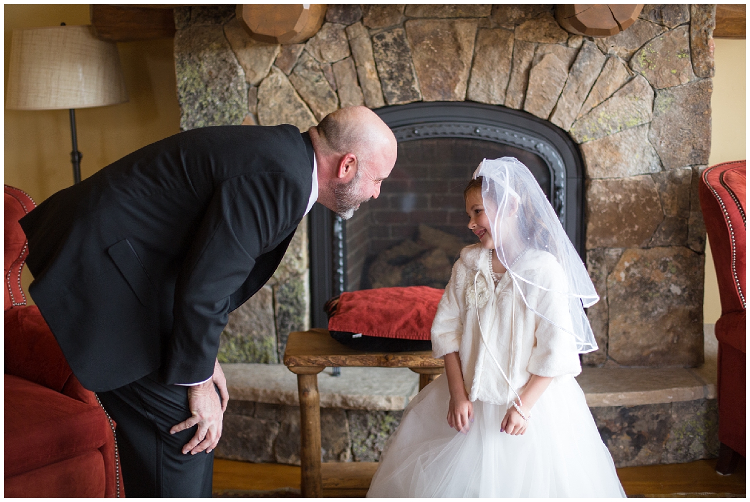 The flower girl smiles at a guest at a Breckenridge wedding.