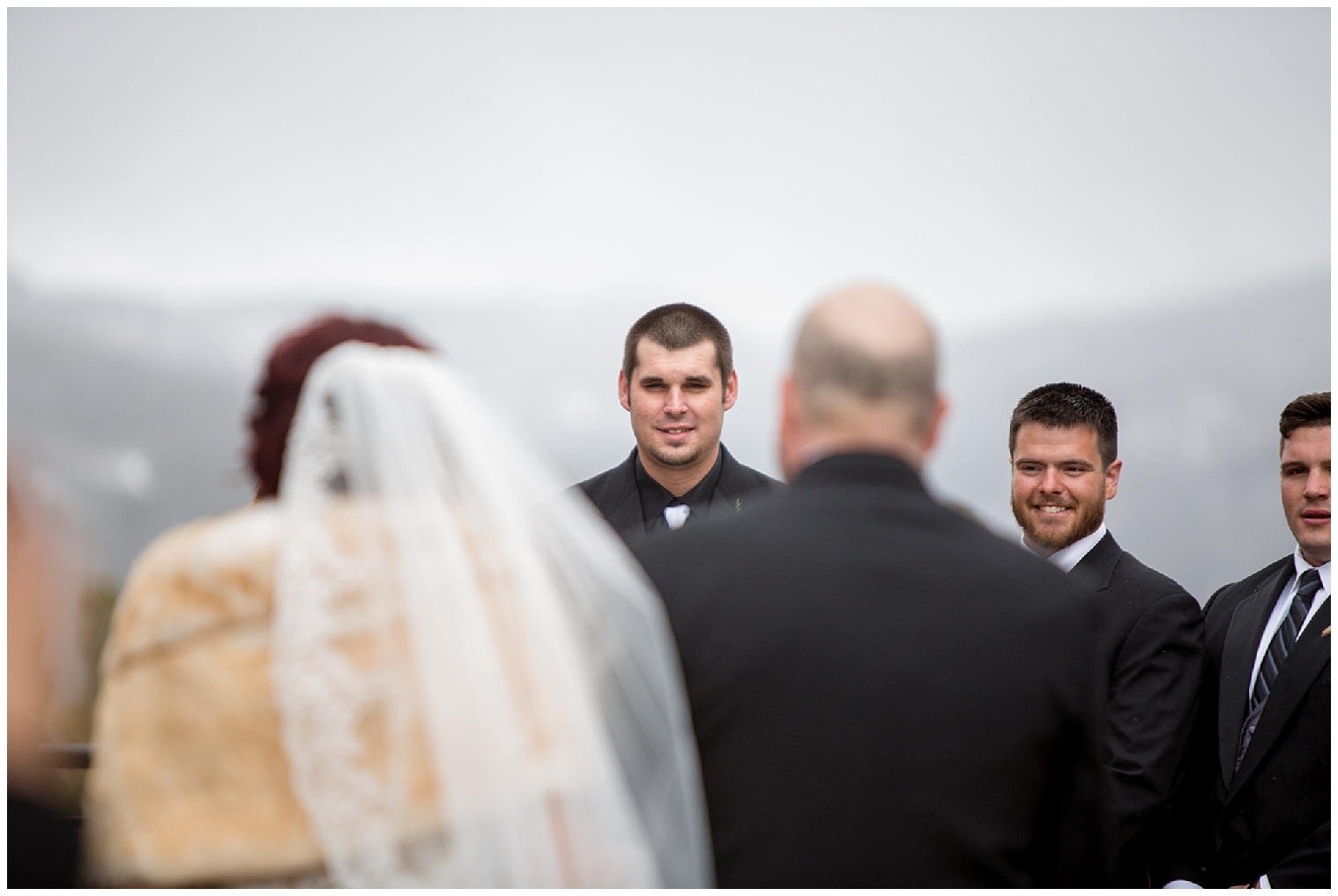 Groom looks at his bride as she is walked down the aisle by her father at a Breckenridge wedding.