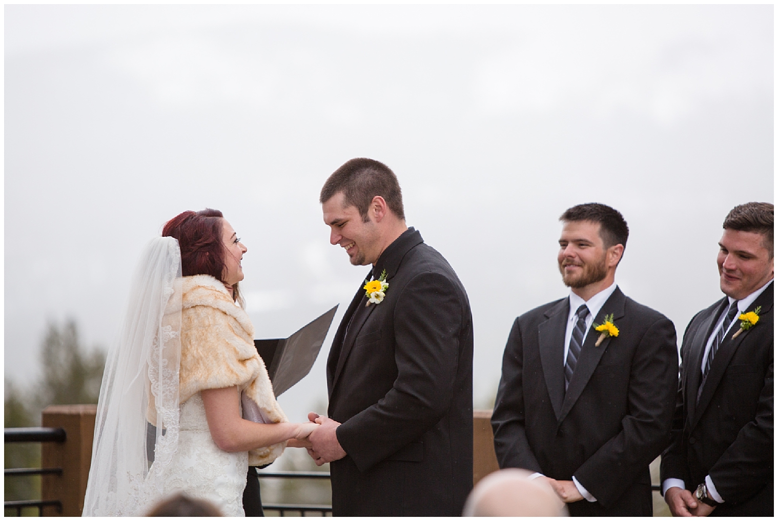 The wedding couple laugh together at the altar at their Colorado mountain wedding at Sevens.