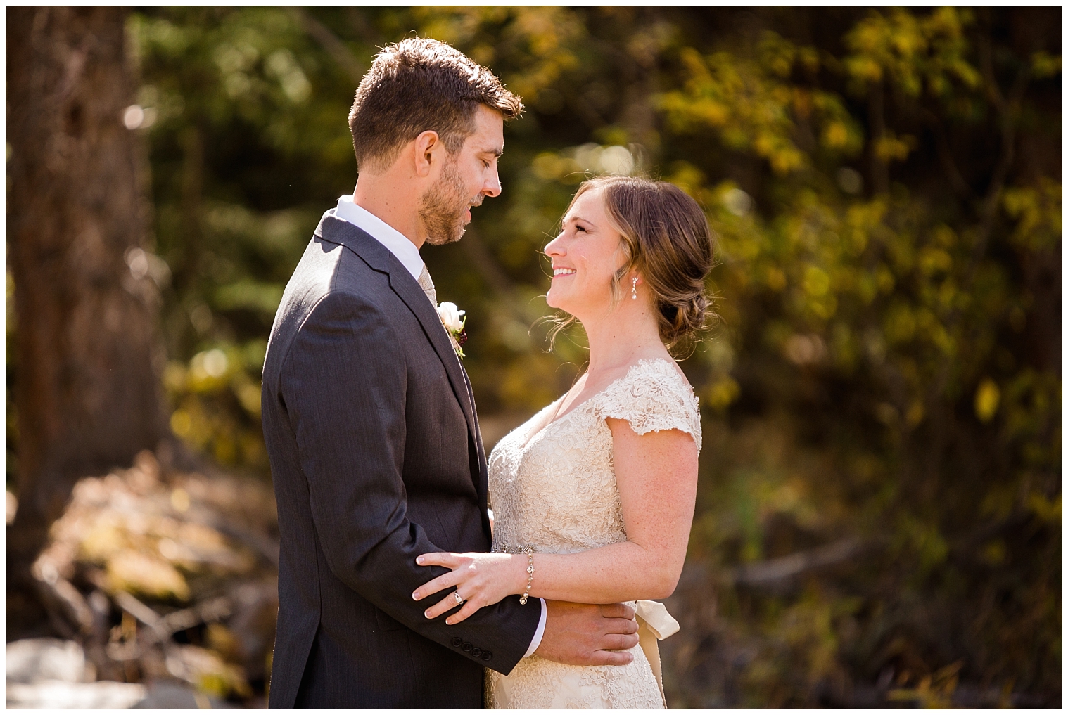 Before their Copper Mountain wedding, the groom smiles down at his bride during their first look portraits.