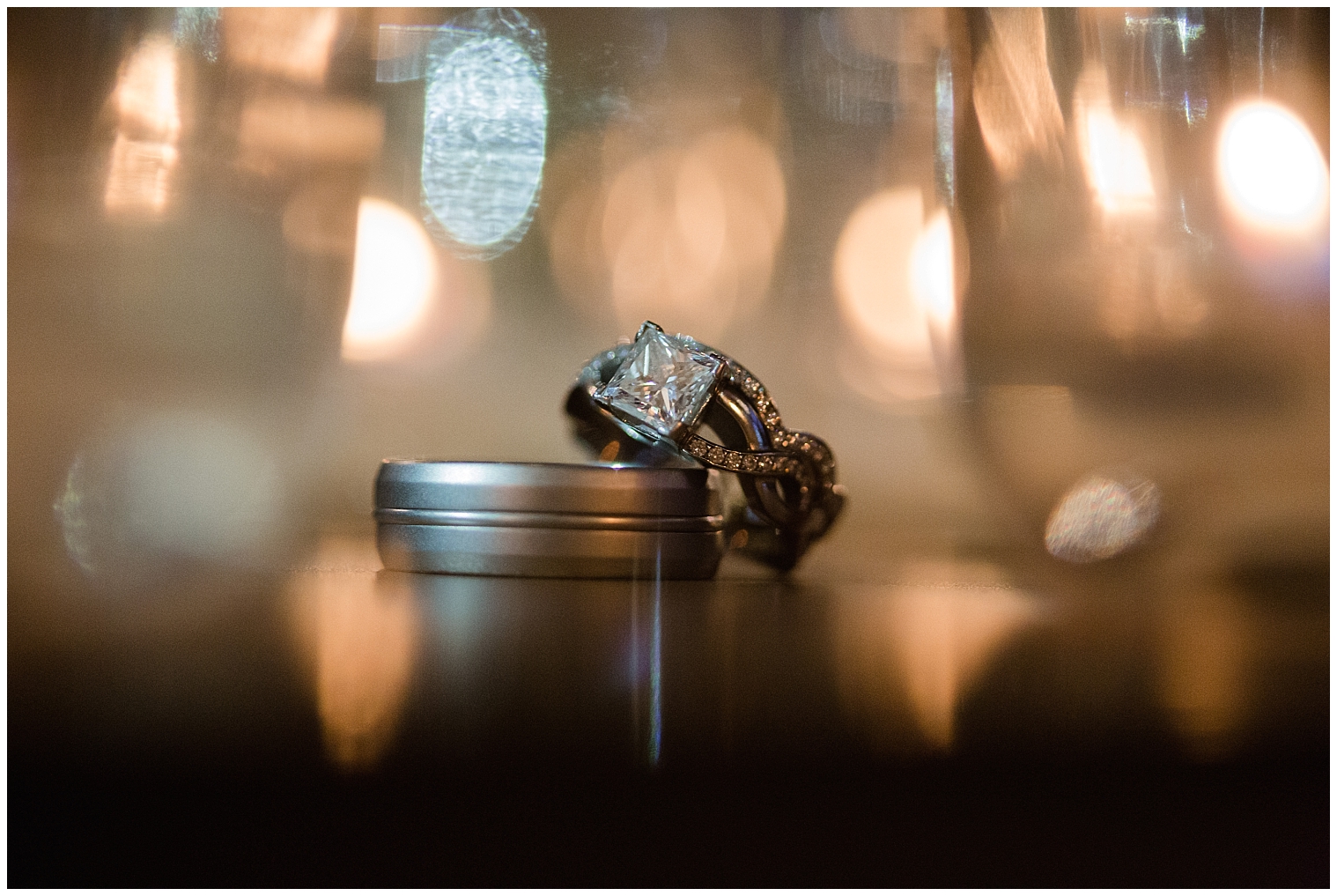 Shot of the wedding rings with lights behind them by a Colorado mountain wedding photographer.