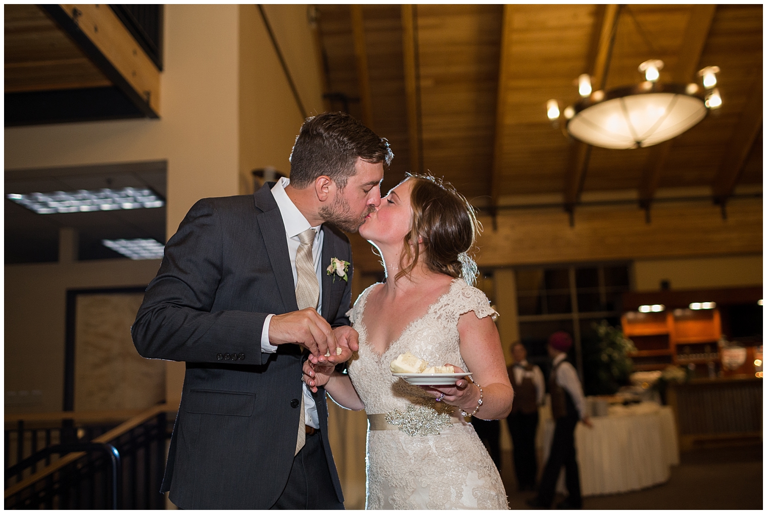 At their Copper Mountain wedding reception, the bride and groom kiss after cutting the cake.