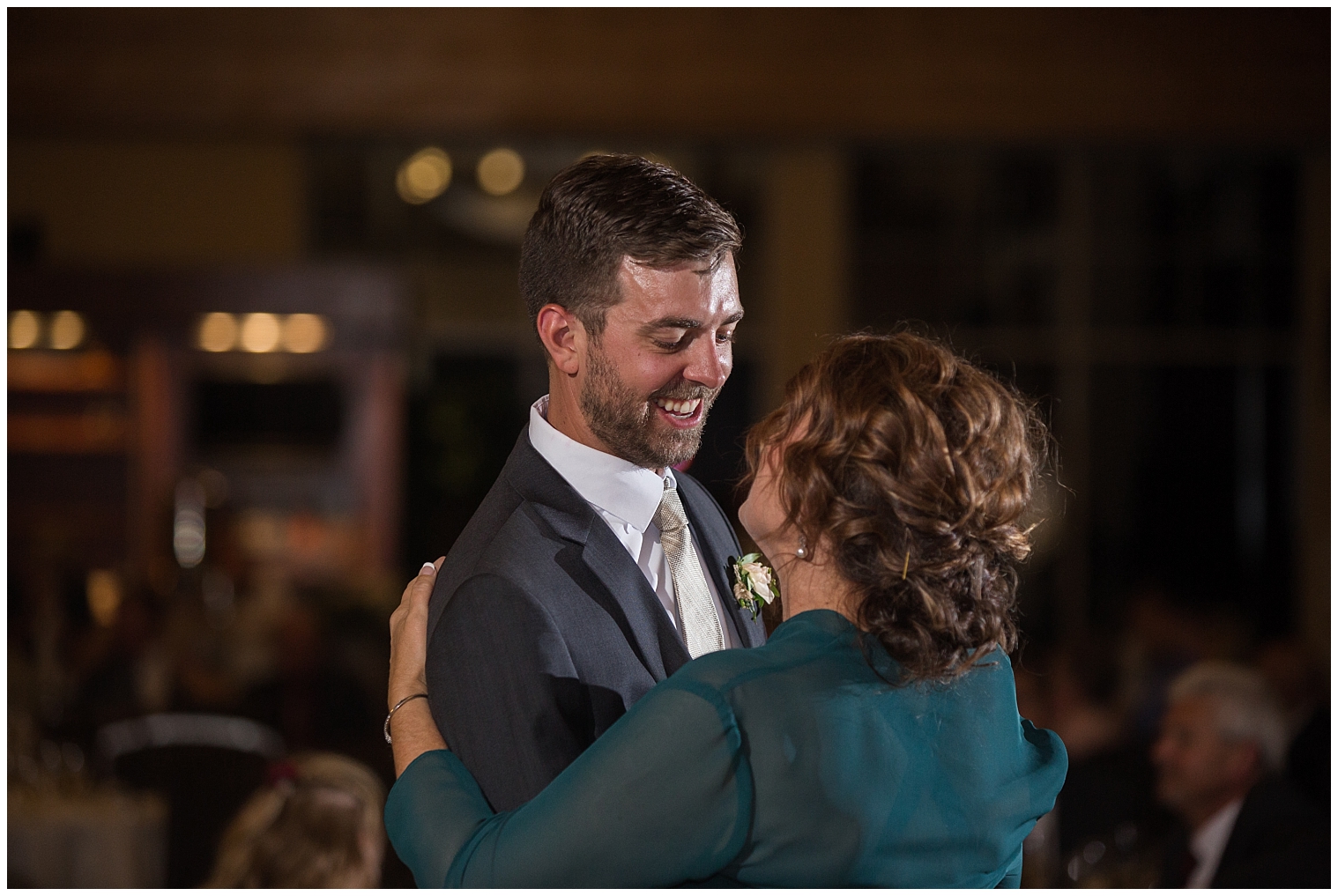 The groom smiles while dancing with his mother in the mother-son dance.