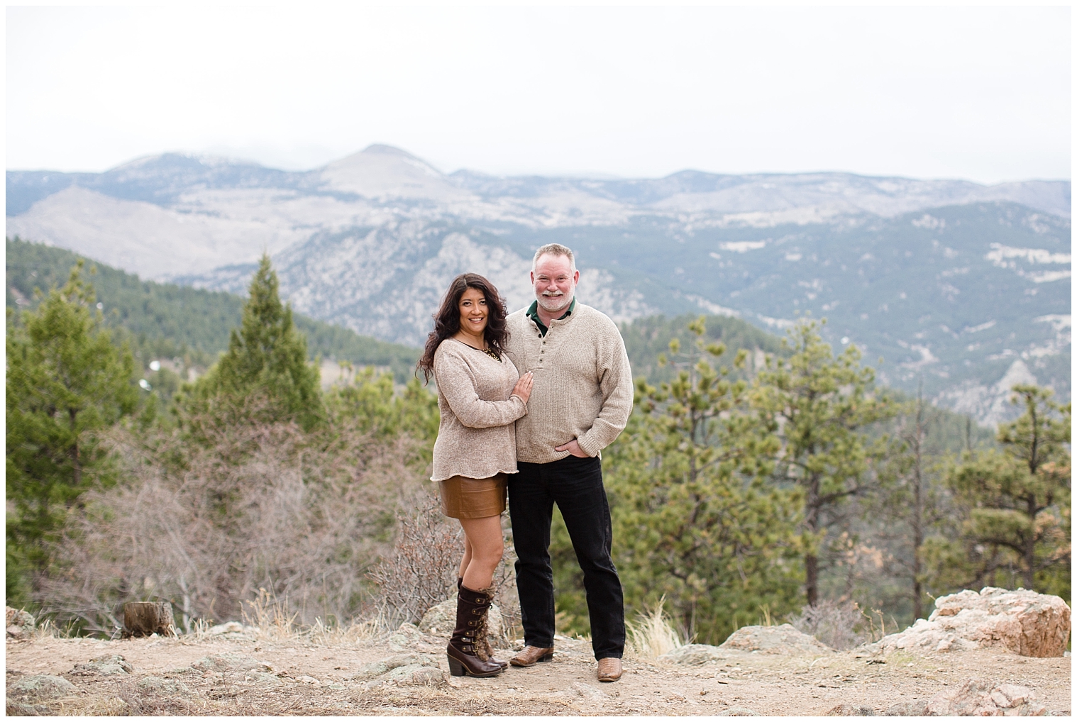Man and woman stand together with mountain views behind them at their Breckenridge engagement session.