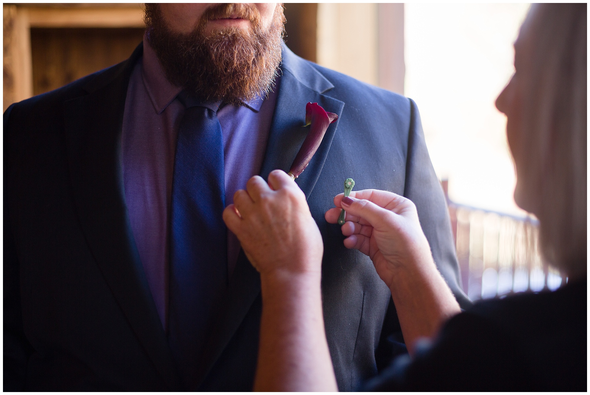 Groom's mother pins on his boutonniere for his Breckenridge elopement.