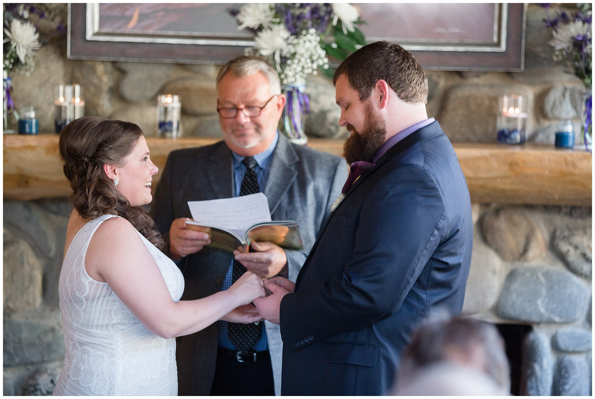 Groom places the ring on his bride's finger during their breckenridge cabin elopement ceremony.