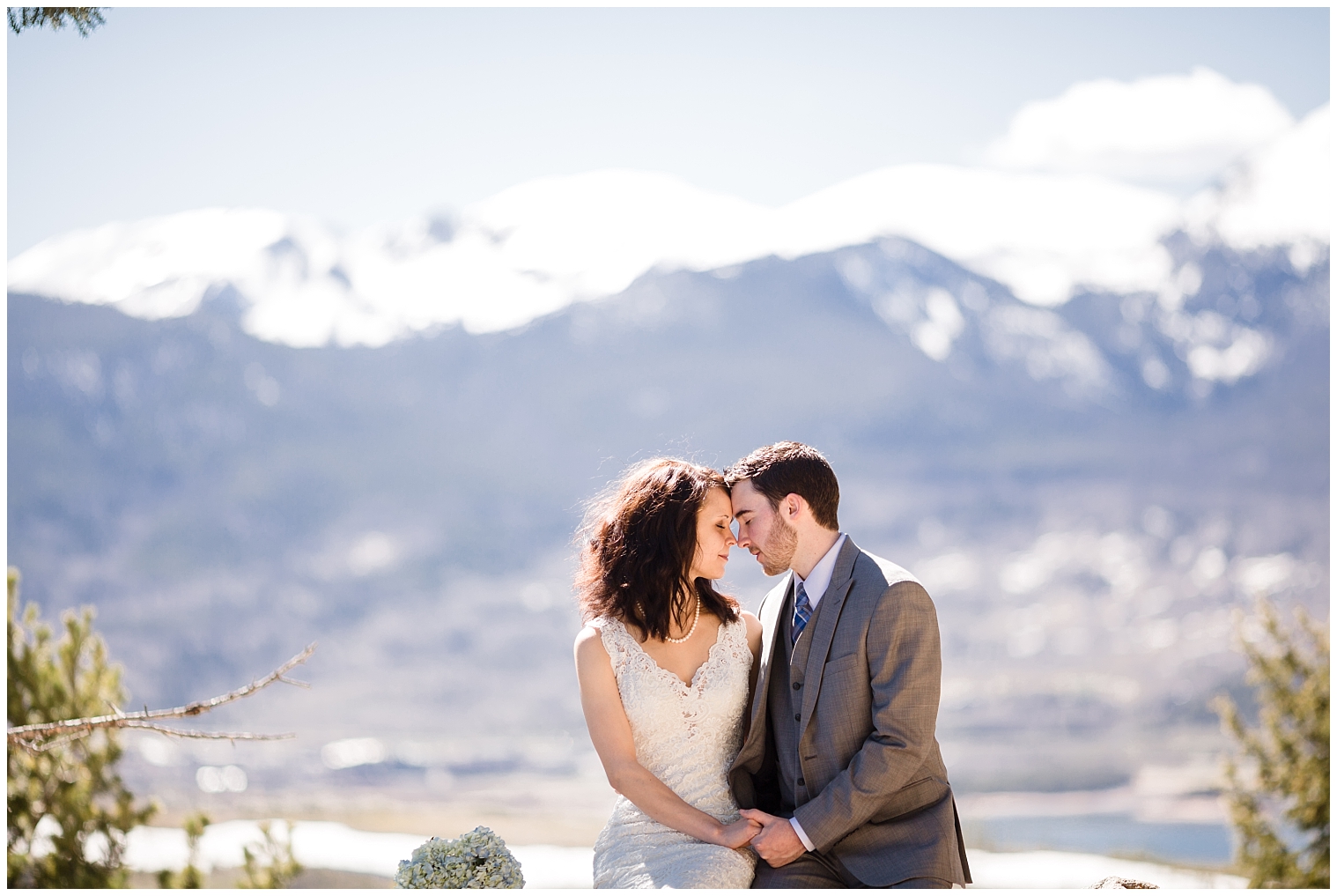 The bride and groom sit on a rock together at their Sapphire Point Overlook elopement.