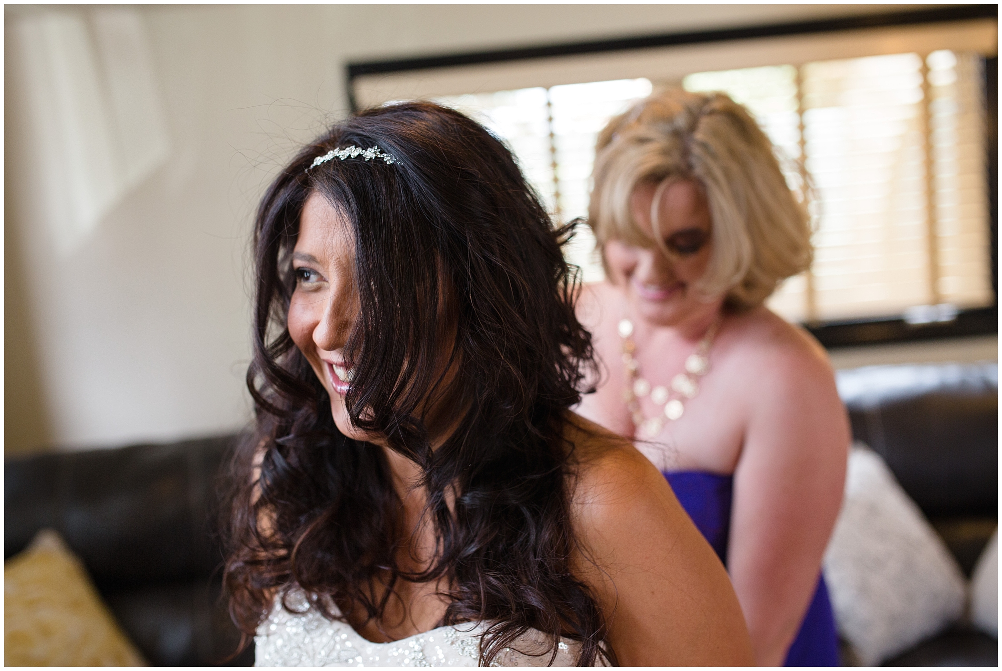 Bridesmaid helps the bride into her dress at a Breckenridge mountain wedding.