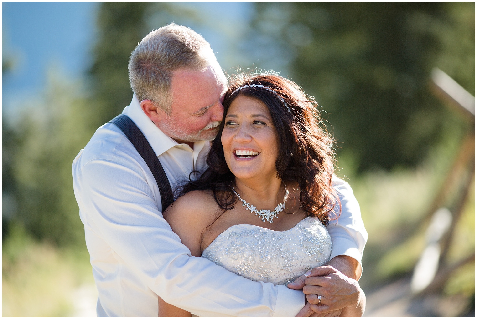 Bride laughs while her groom hugs her at their Breckenridge wedding.