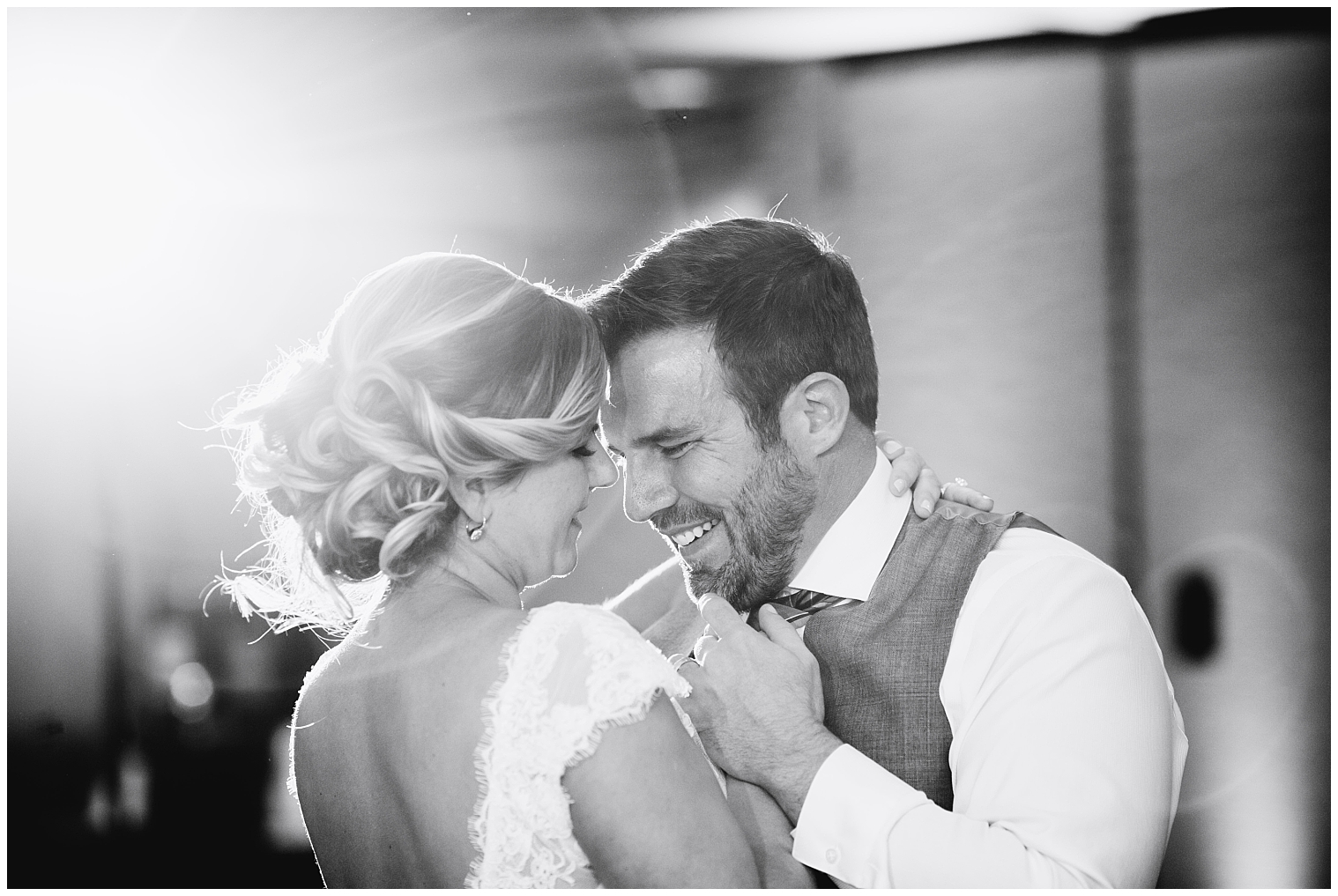 Groom laughs during his first dance with his bride at a Mountain Thunder Lodge wedding.