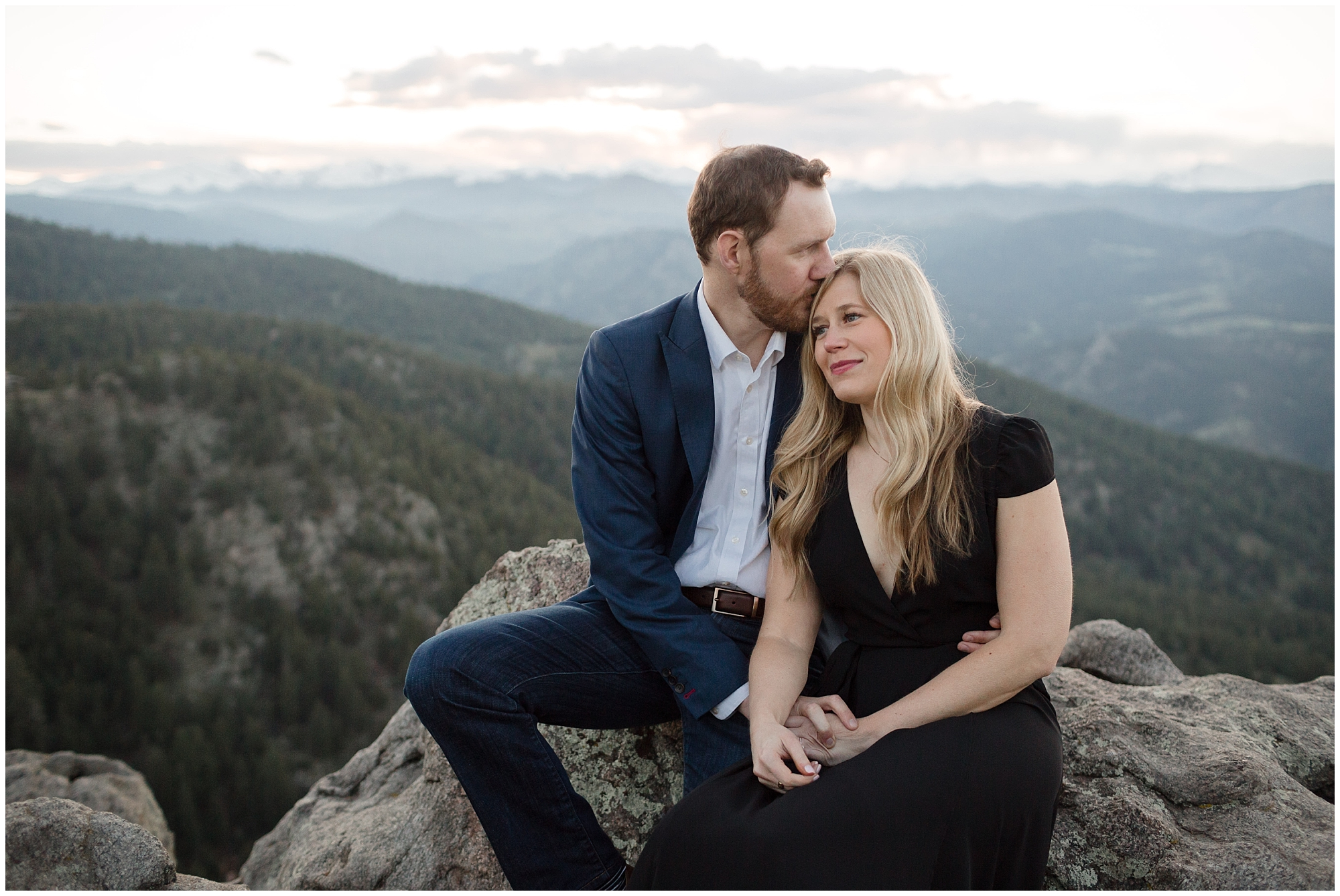 Couple sits together on the rocks during their Colorado mountain engagement photographer.