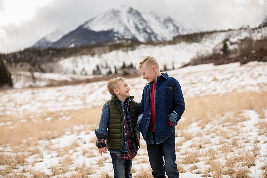 two young brothers laughing with each other in front of snowy Breckenridge mountains