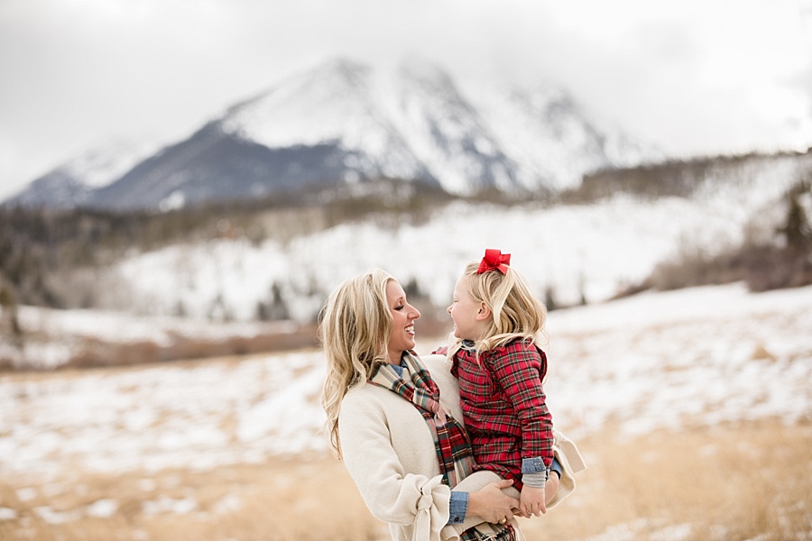 mother and daughter pose together with snowy mountain backdrop
