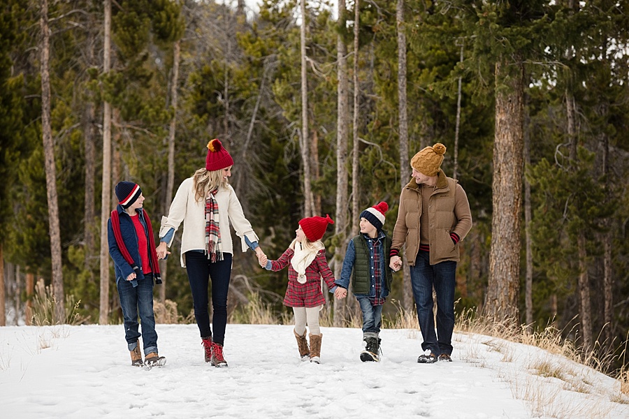 family wearing winter hats walk together at sapphire point Breckenridge Colorado