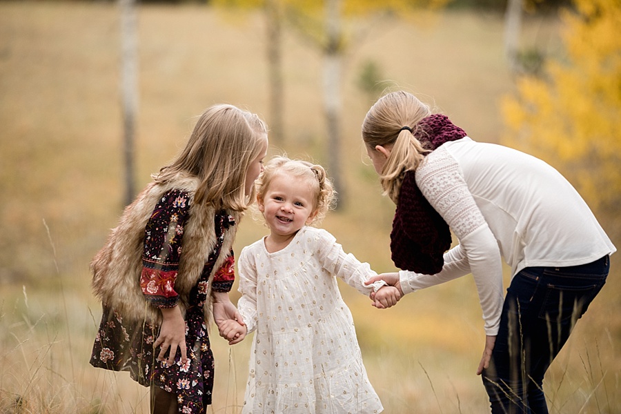 three sisters laughing together in conifer Colorado during autumn