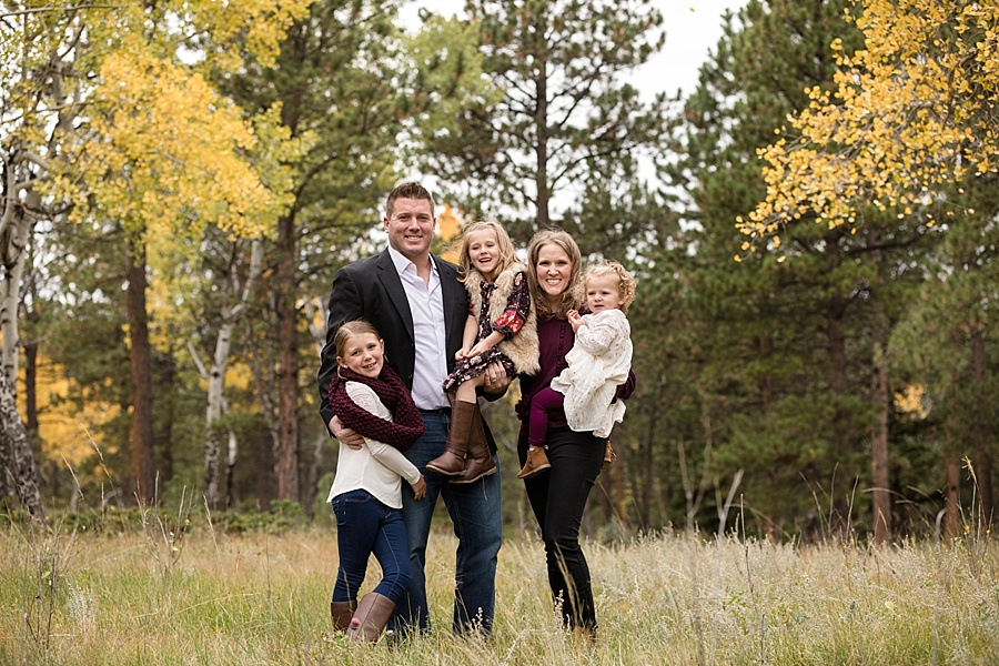 family poses together in meadow in conifer Colorado