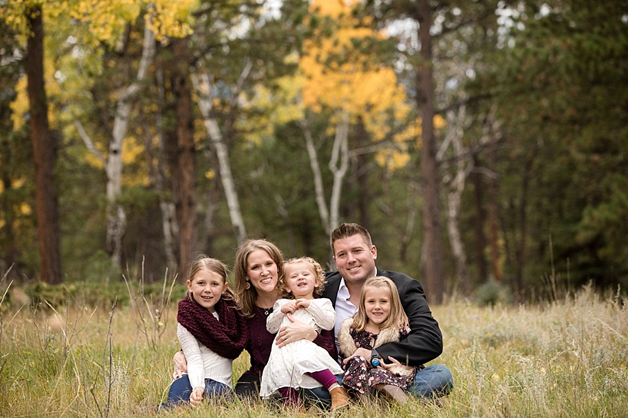 family sitting in the meadow during fall in Breckenridge Colorado 