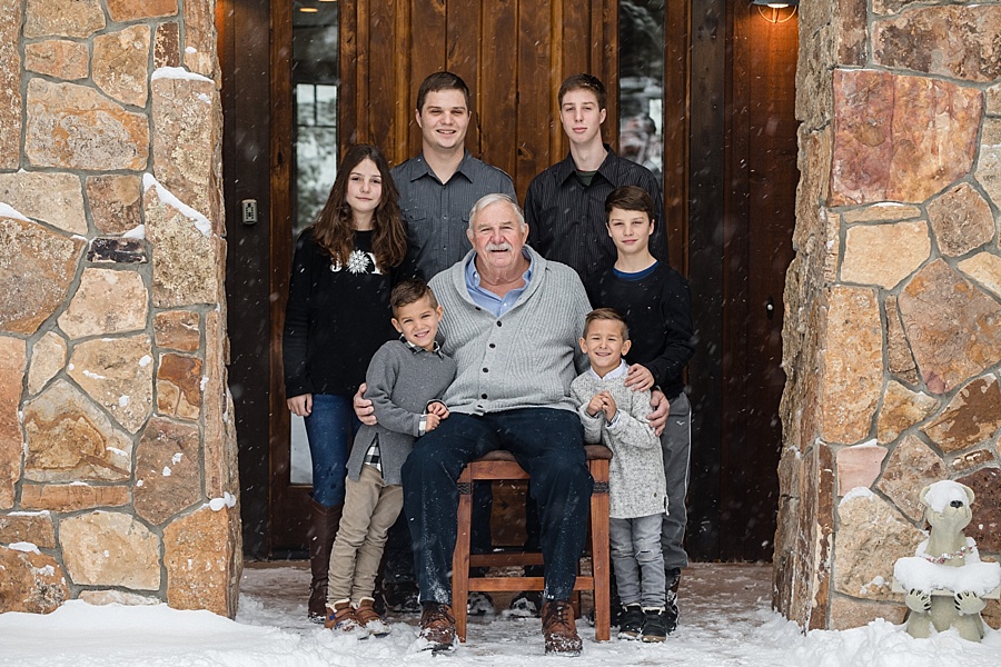 six grandchildren pose with their grandfather next to a cabin in Breckenridge Colorado 