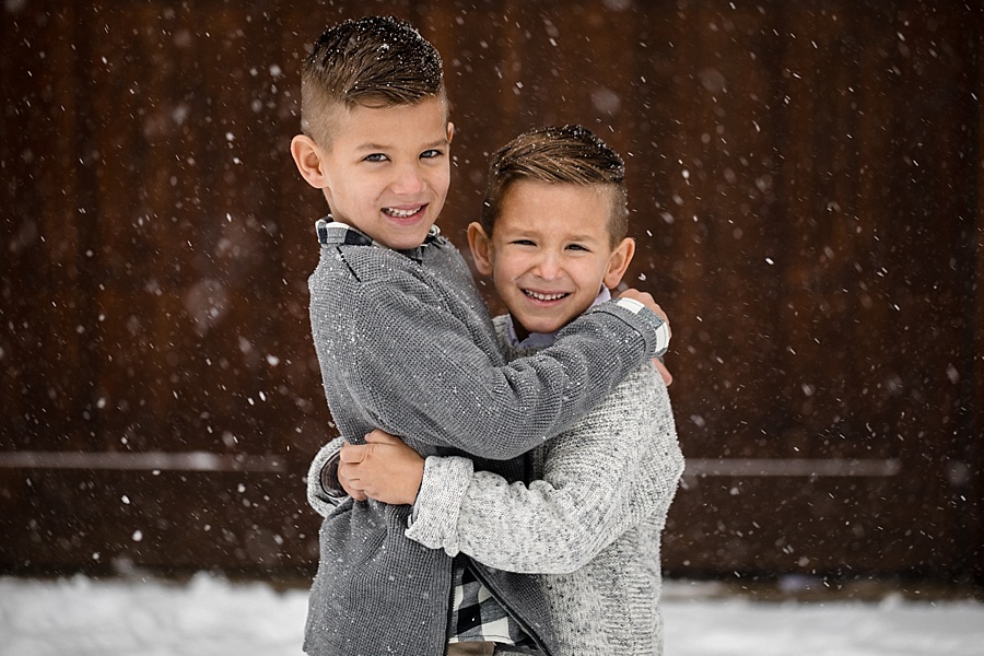 cute young brothers pose next to cabin in the snow in Breckenridge Colorado 