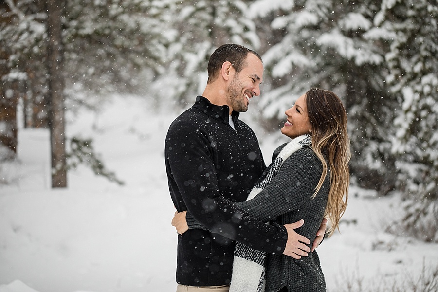 married couple laughs and looks at each other in the snow in Breckenridge Colorado 