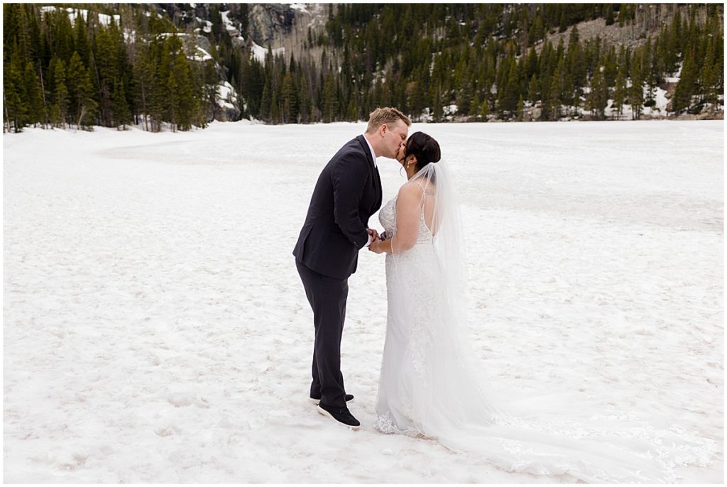 Bride and groom together standing on snow during elopement at Rocky Mountain National Park