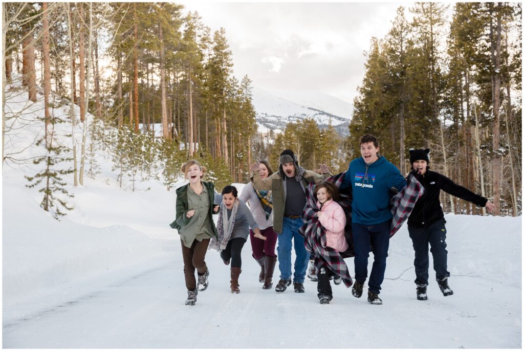 large family running and being silly in the snowy Colorado mountains in Breckenridge