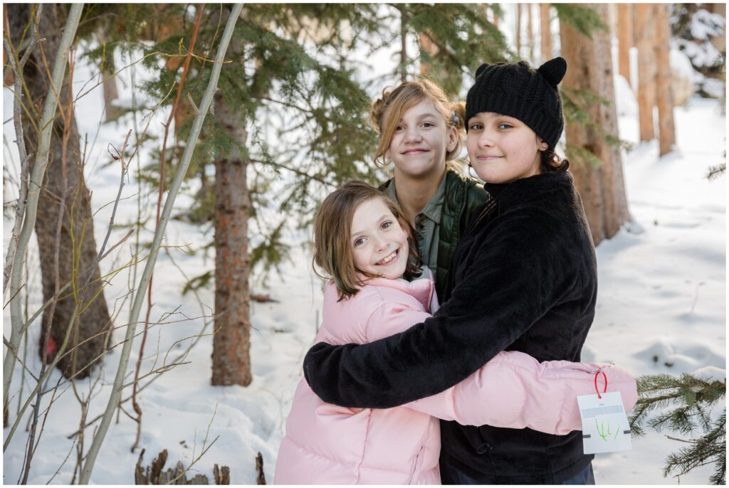 three siblings hugging in the snow in Breckenridge Colorado