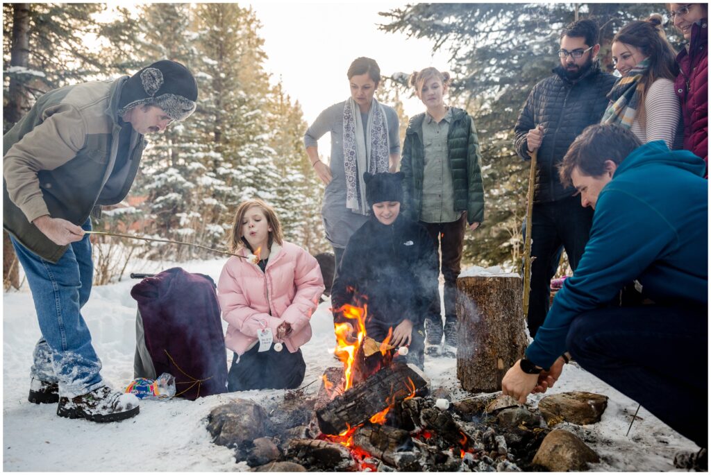 amily candids toasting s'mores by the fire in Breckenridge