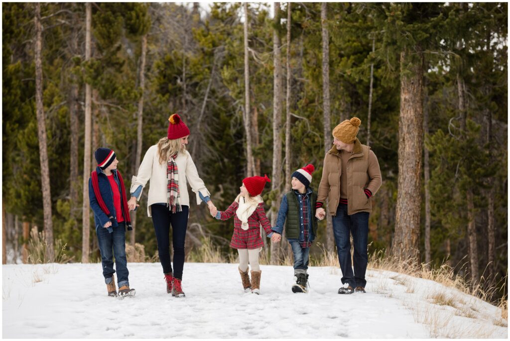 family wearing winter hats walk together at sapphire point Breckenridge Colorado